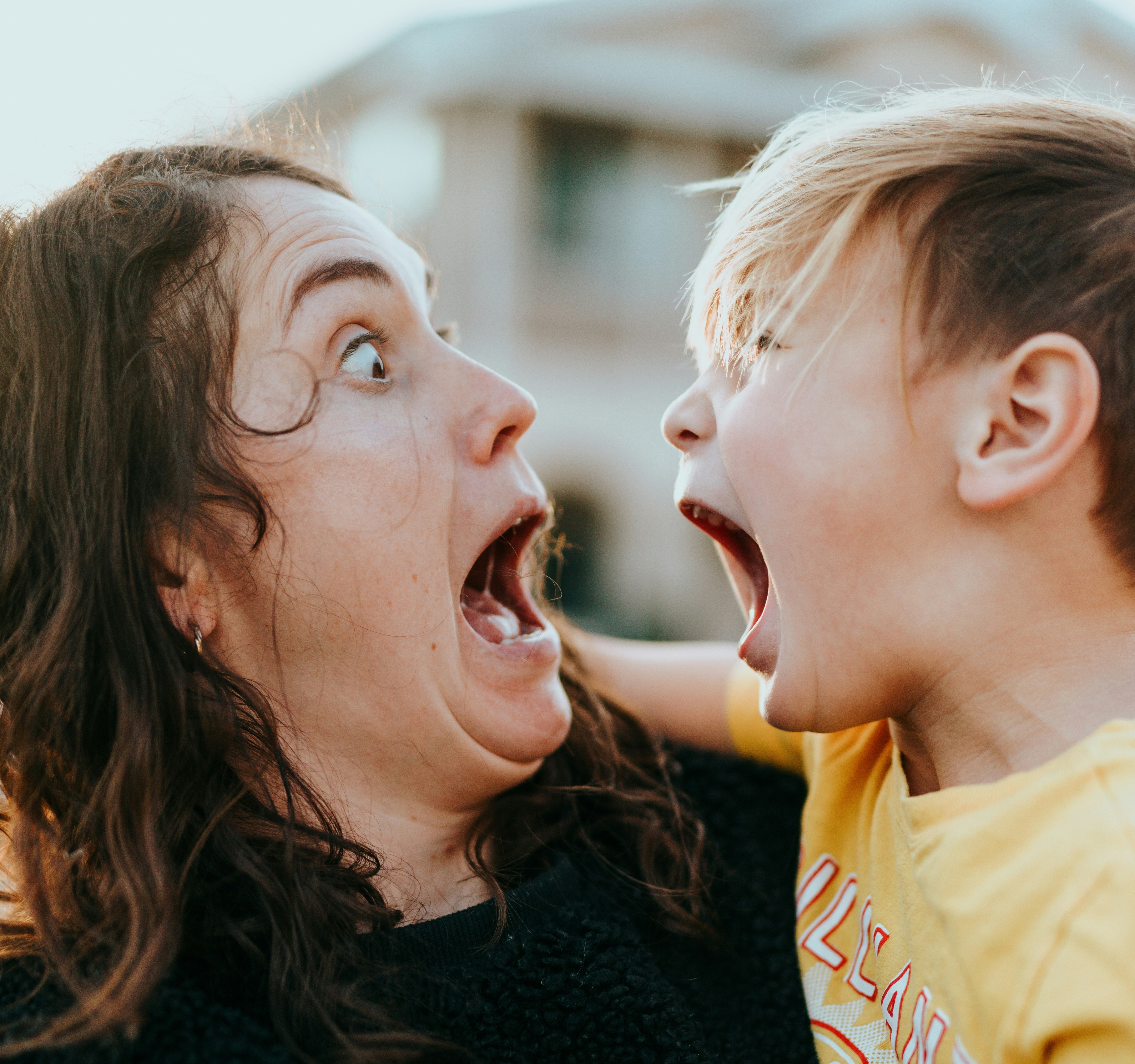 A mother looks at her son with surprise as the child shows anger.