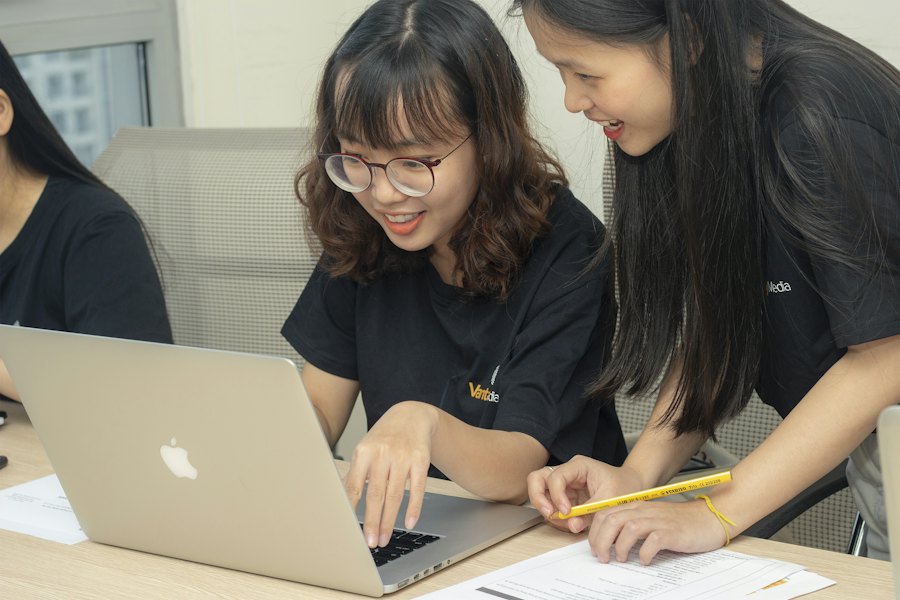 Two students work together on a laptop.
